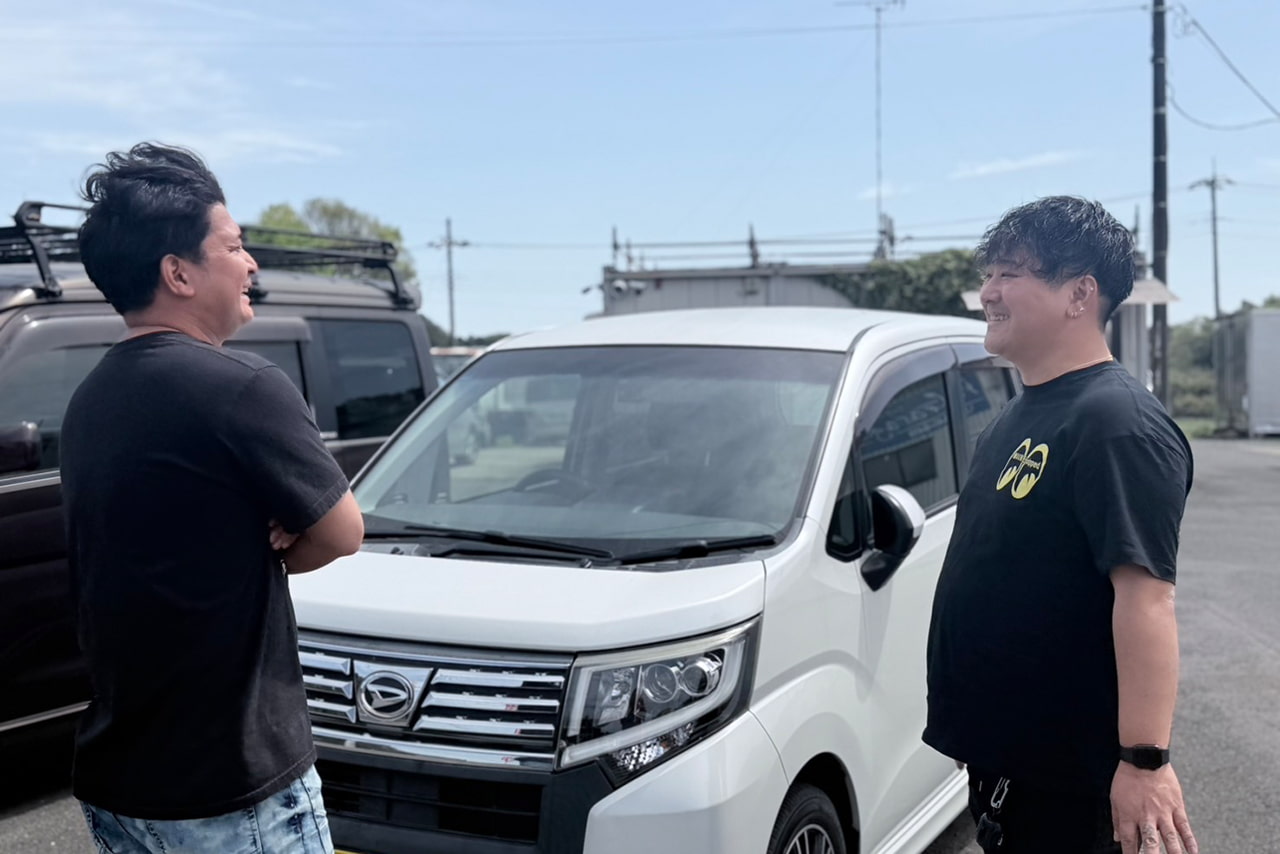 車の前で相談するスタッフとお客様