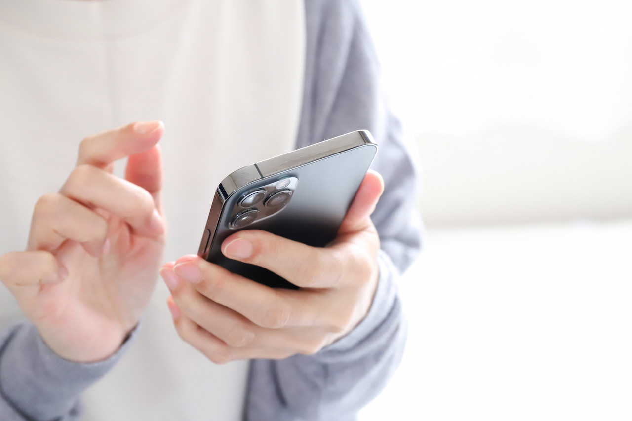 スマートフォンを操作する手元